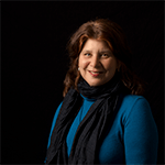 studio photograph of woman sitting in blue top